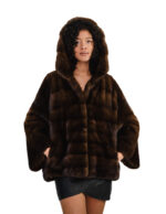 Jacke 44-56, Kapuze aus Halbmelz, horizontaler Pelzbesatz am Brustbereich und durchgehender Lederkordelzug am Ärmel.