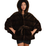 Накидка из полубежевой норки, размер 48/54, с горизонтальной отделкой по всей поверхности, капюшоном и внутренним поясом на талии.